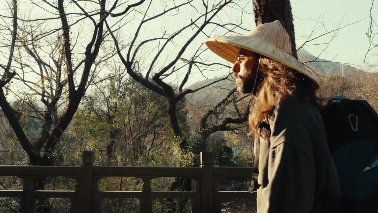 Person Walking in Conical Straw Hat