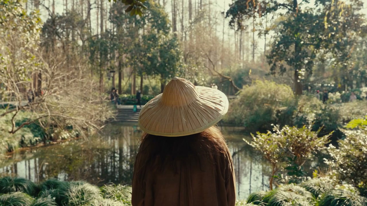 Person in Traditional Hat in Hangzhou Garden