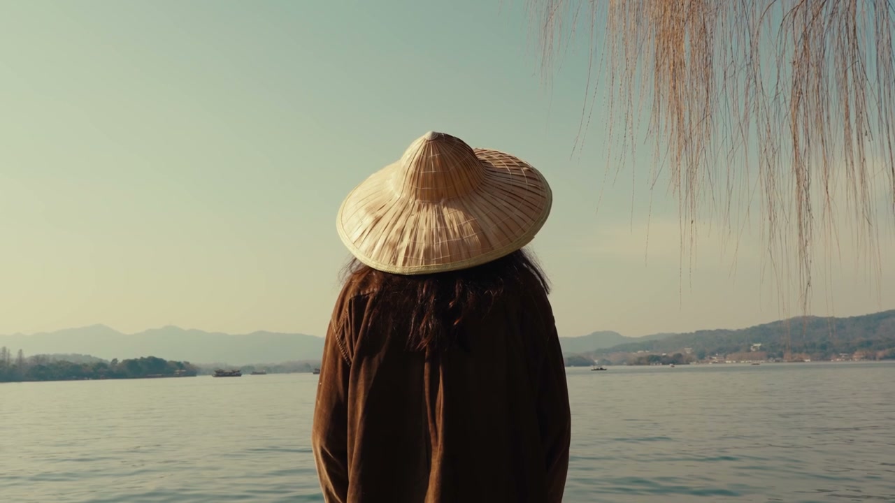 Person in Straw Hat Overlooking Lake in Hangzhou