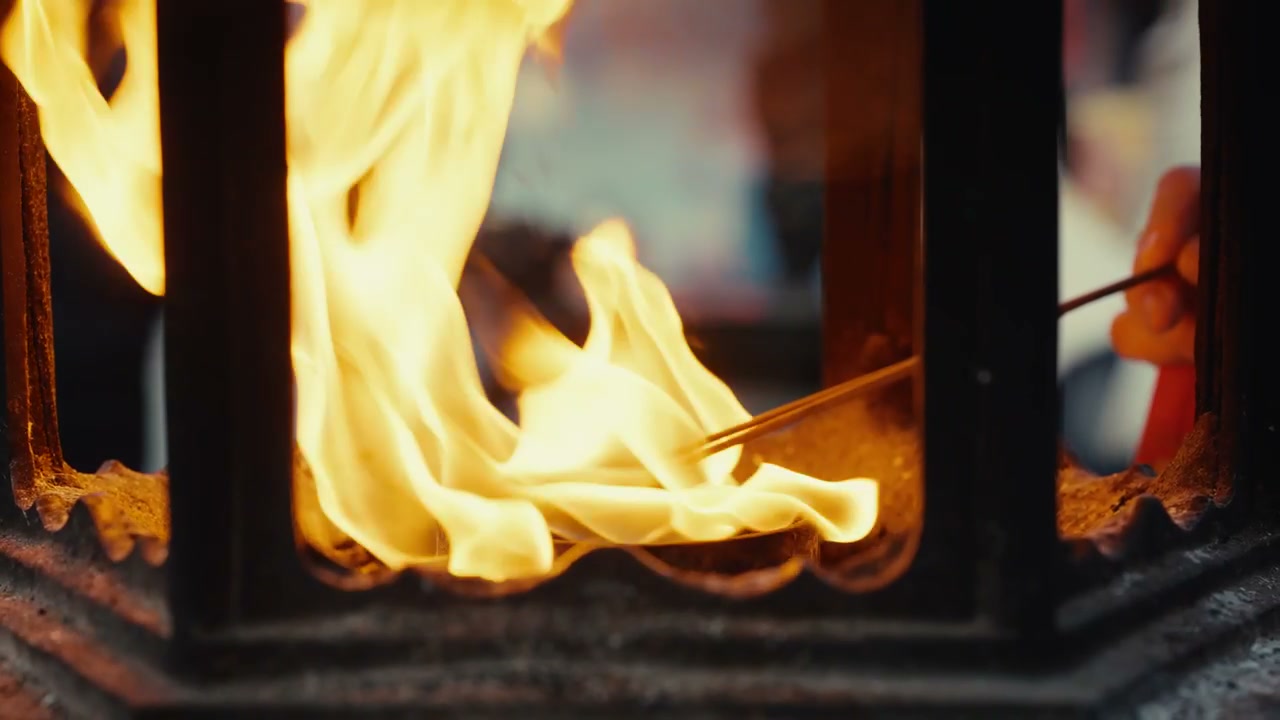 Person Lighting Incense Sticks in Temple