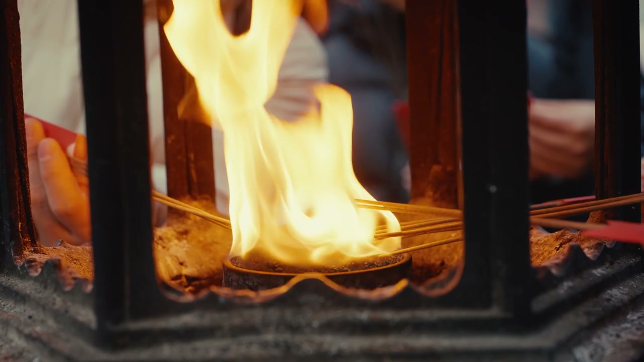 People Lighting Incense Sticks in Temple Fire