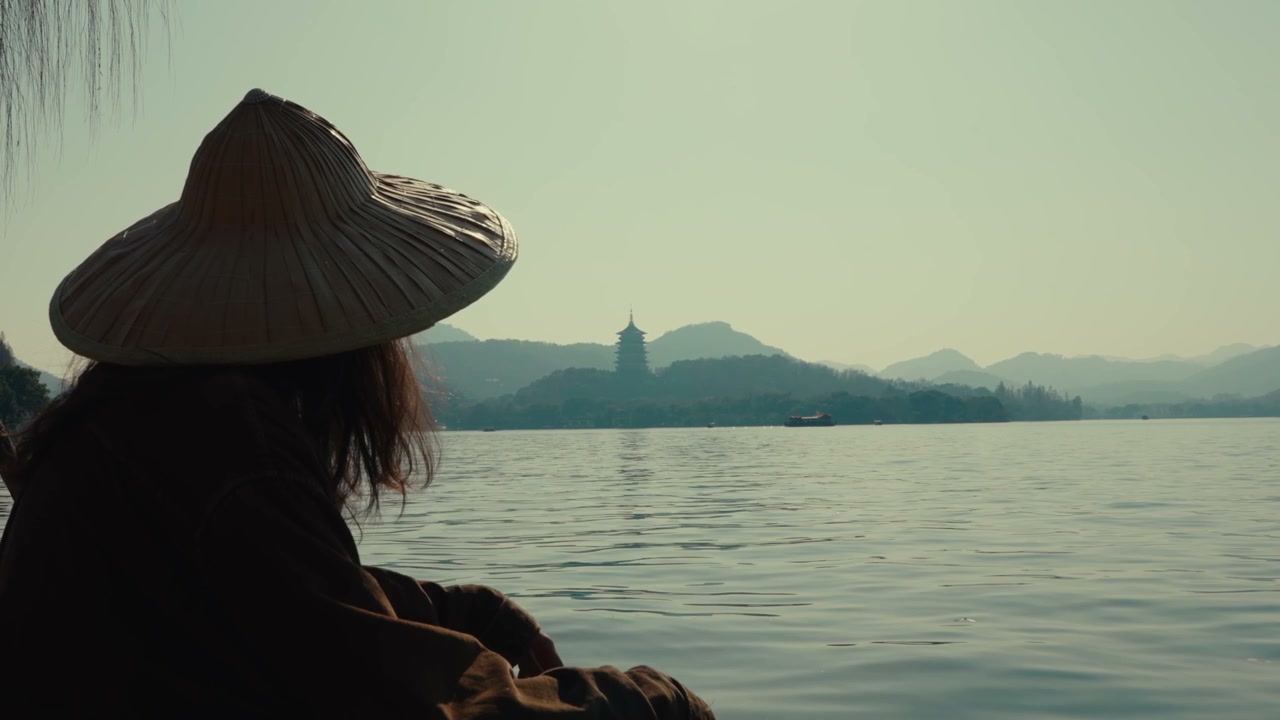 Person in Conical Hat Views West Lake Pagoda
