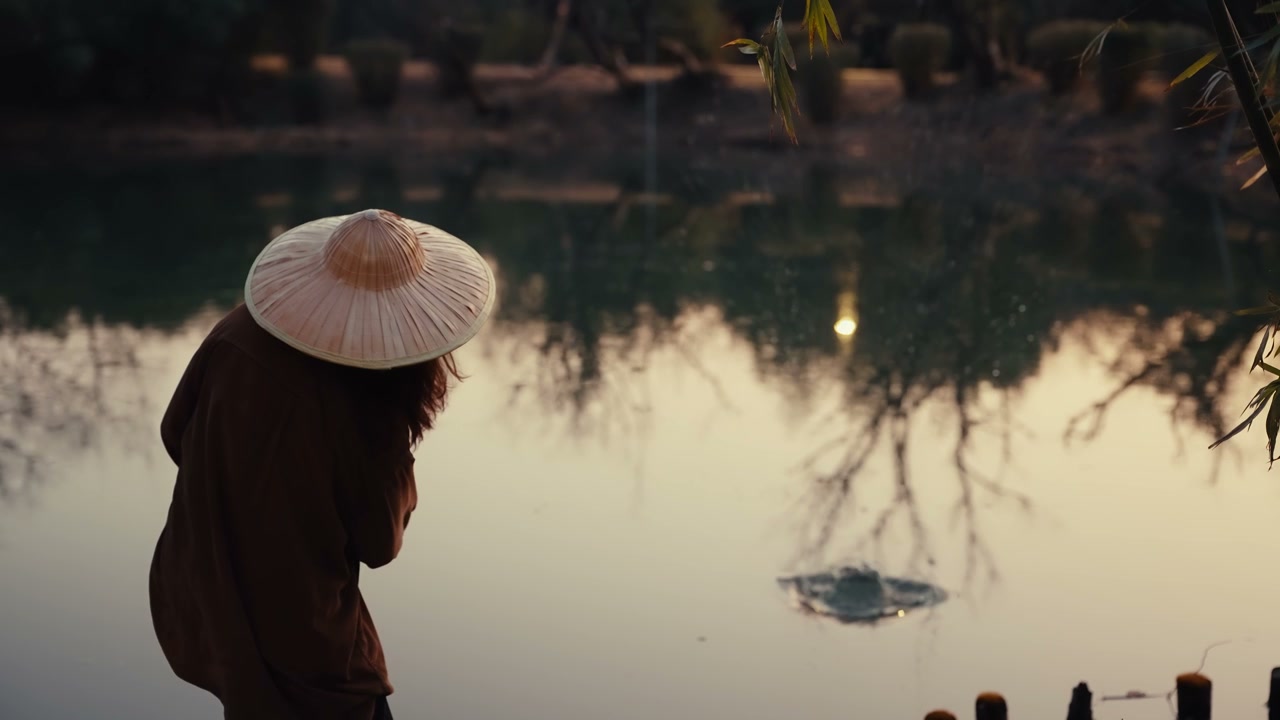 Person Throwing Rocks in a Lake at Sunset