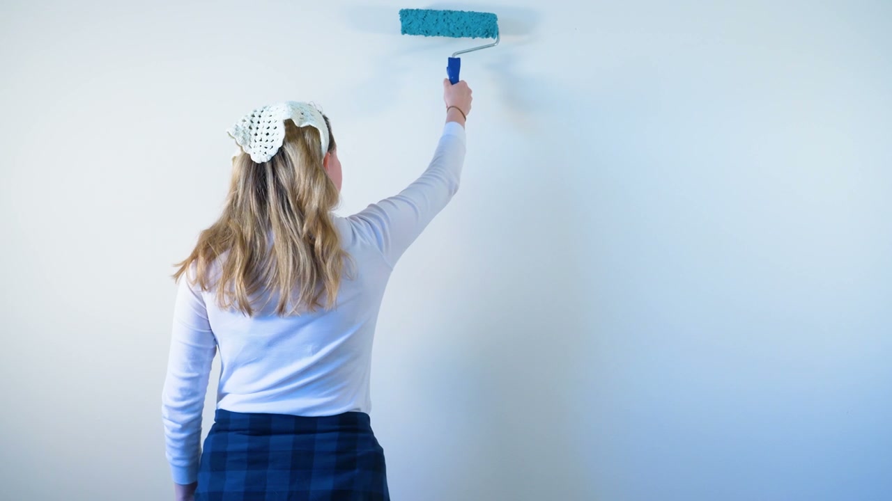 Woman Painting White Wall with Roller