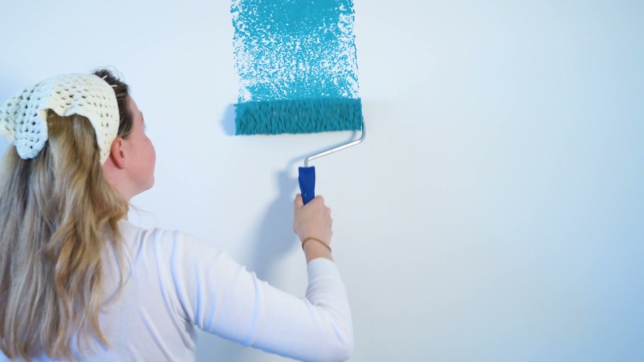 Person Painting Wall Blue with Roller