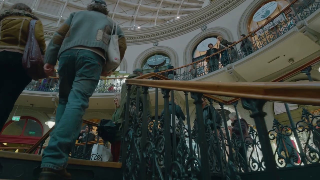 People Climbing Ornate Stairs in a Shopping Arcade