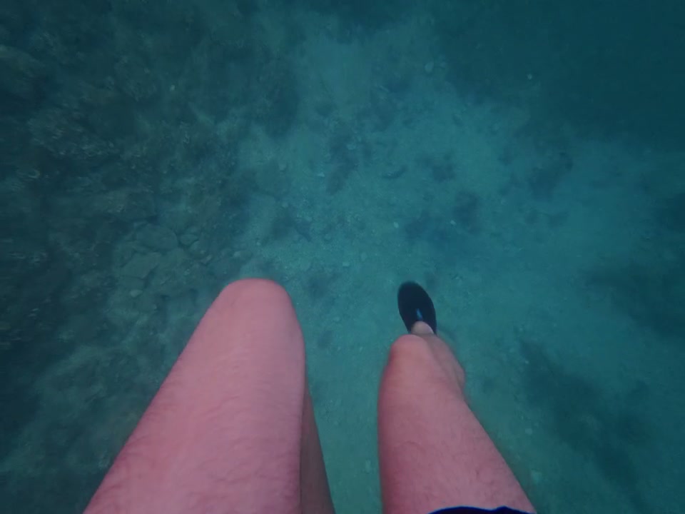 POV Legs Dangling in Clear Ocean Water
