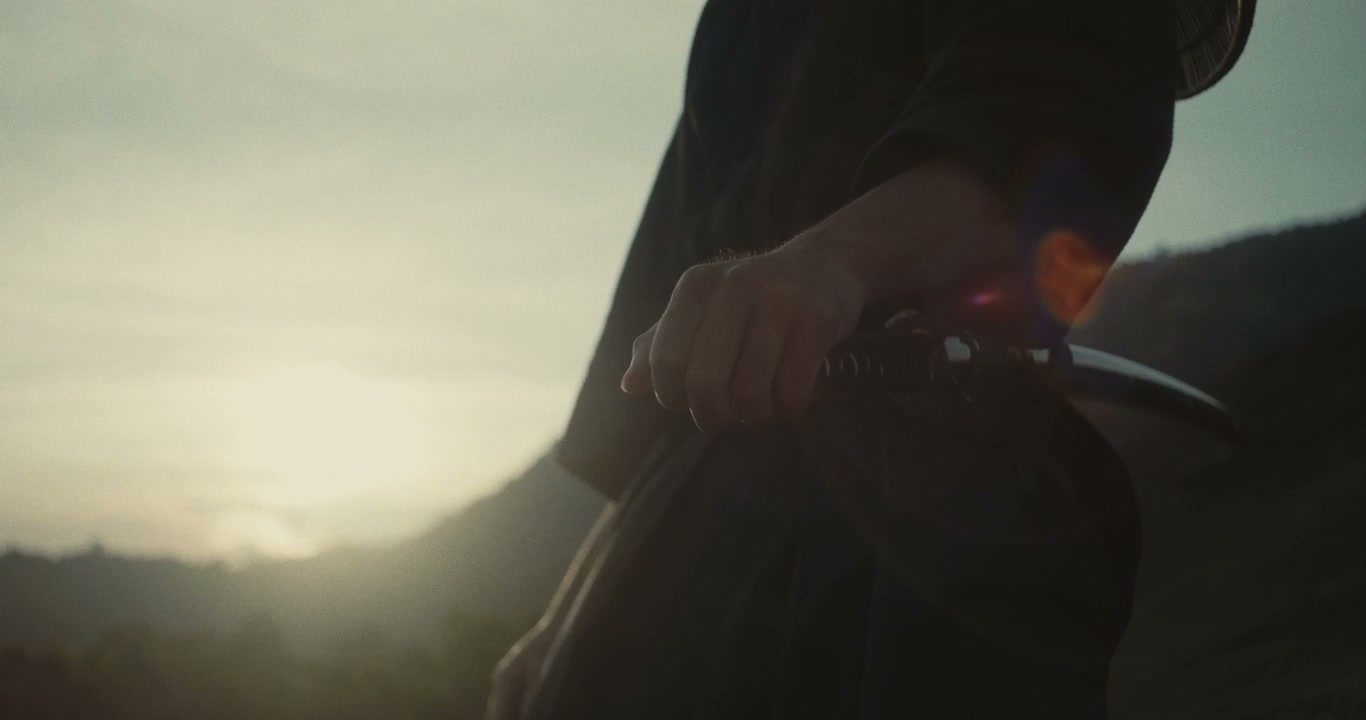 Samurai Gripping Katana at Sunset