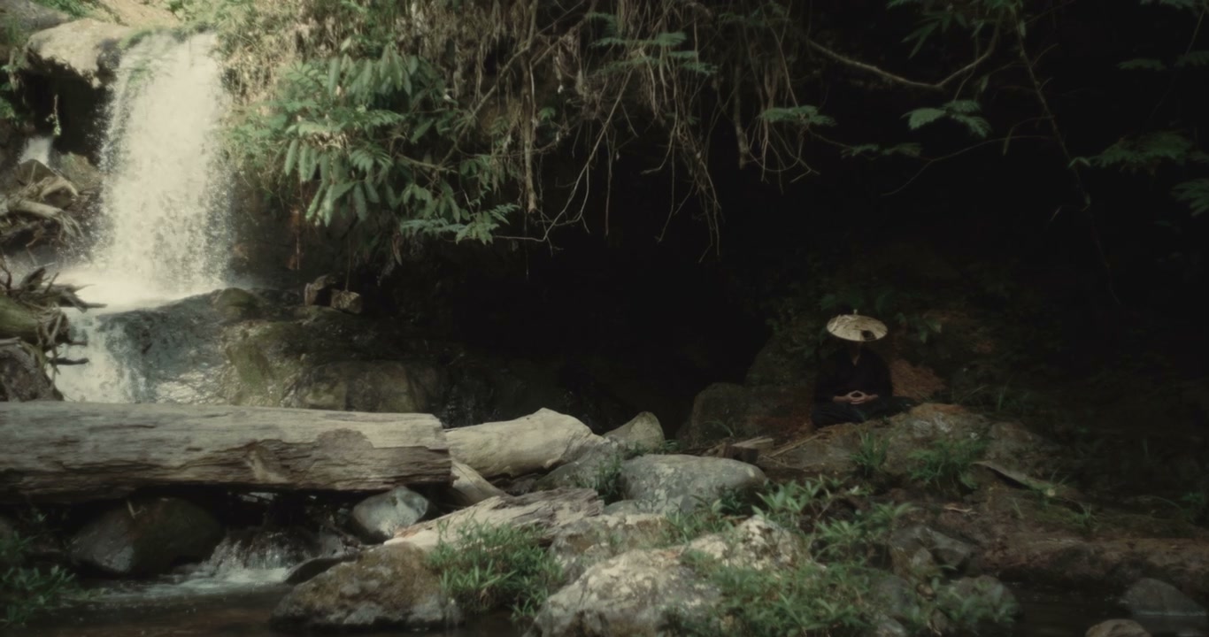 Figure Meditating by Waterfall in Forest