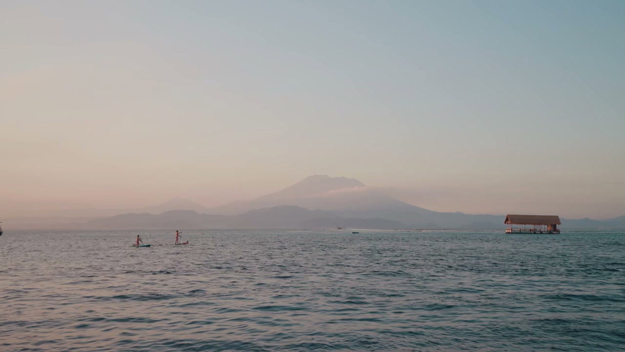 Paddleboarders on Ocean with Distant Mountain