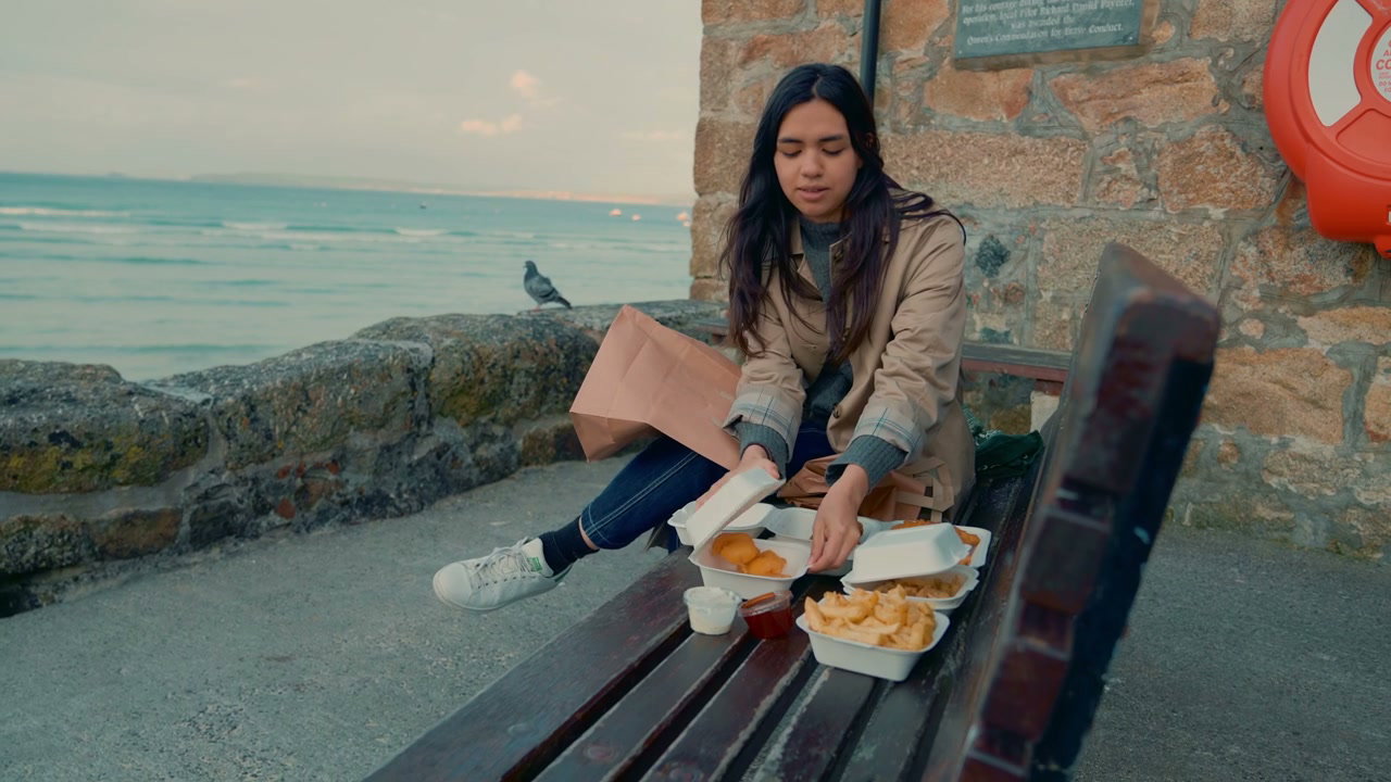 Woman Eating Takeaway by the Sea in St Ives