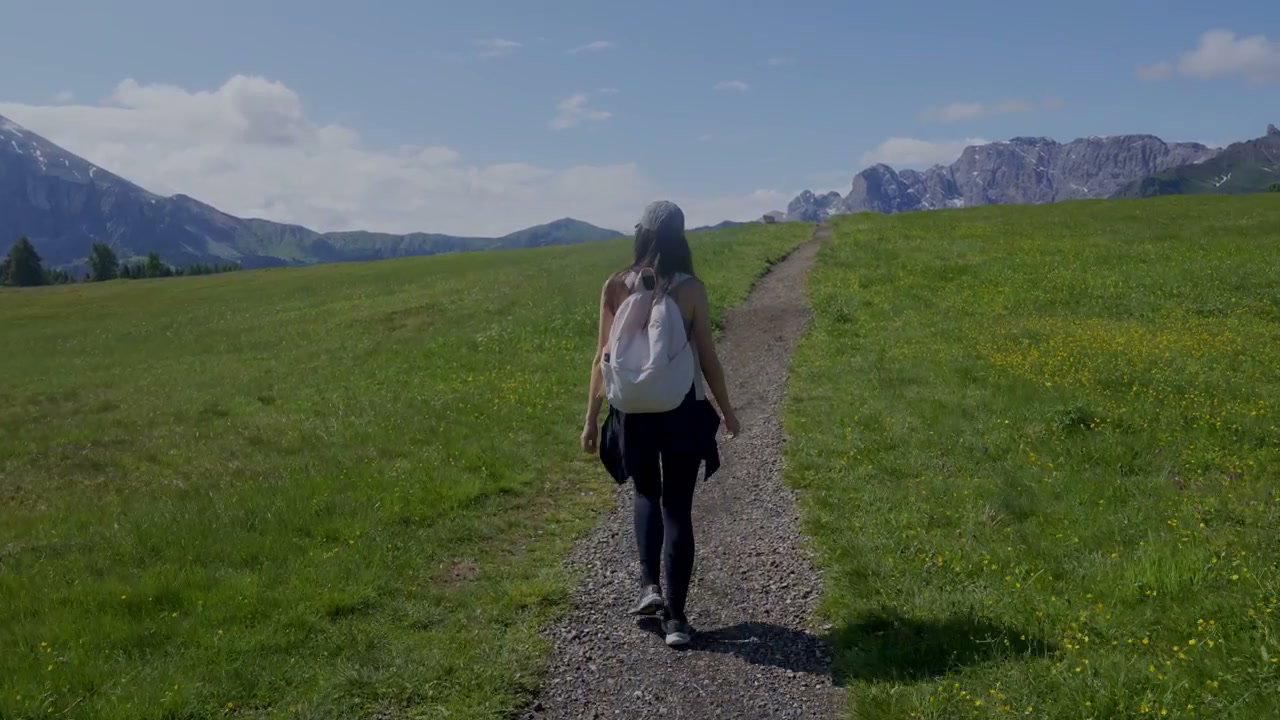 Person Hiking Through Alpe di Siusi Meadows