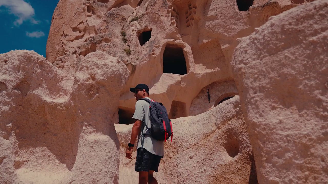 Person Descending Rocky Cave Dwellings