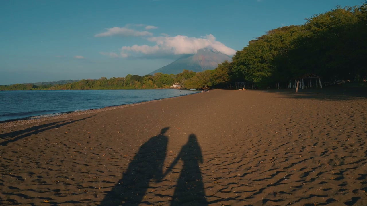 Couple's Shadows on Beach with Volcano View