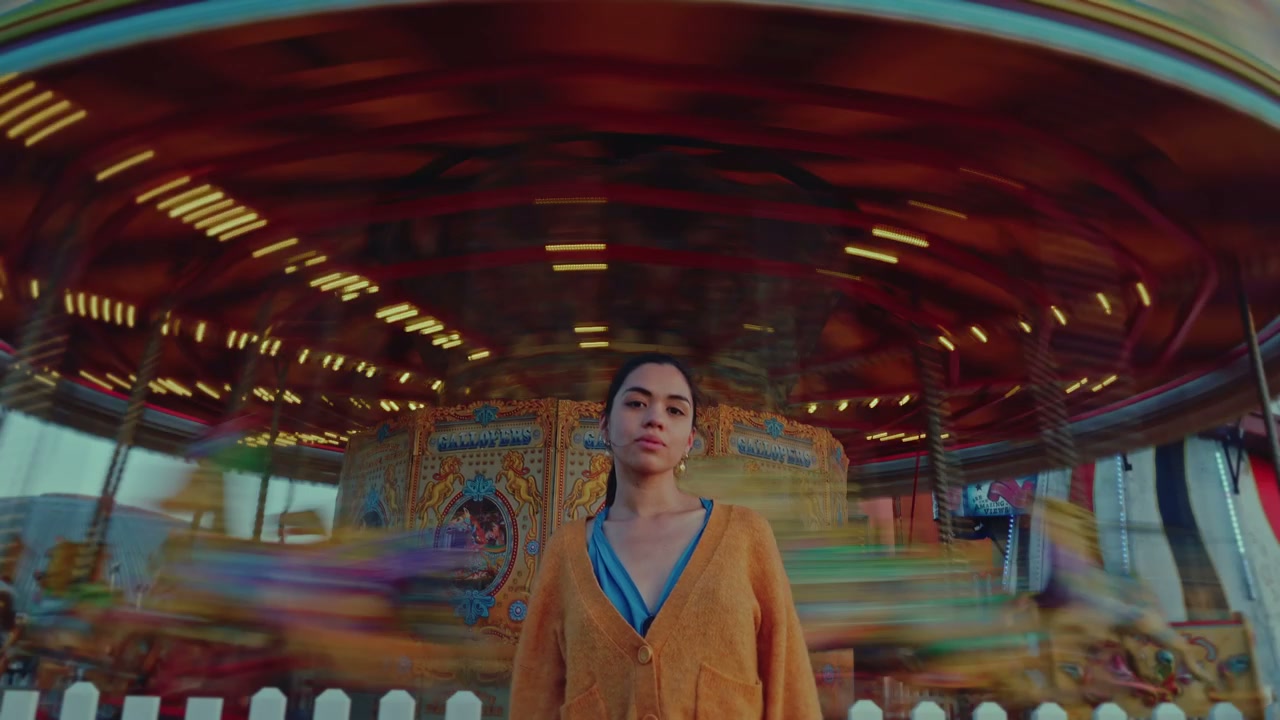 Woman Standing by Spinning Carousel at Brighton Pier