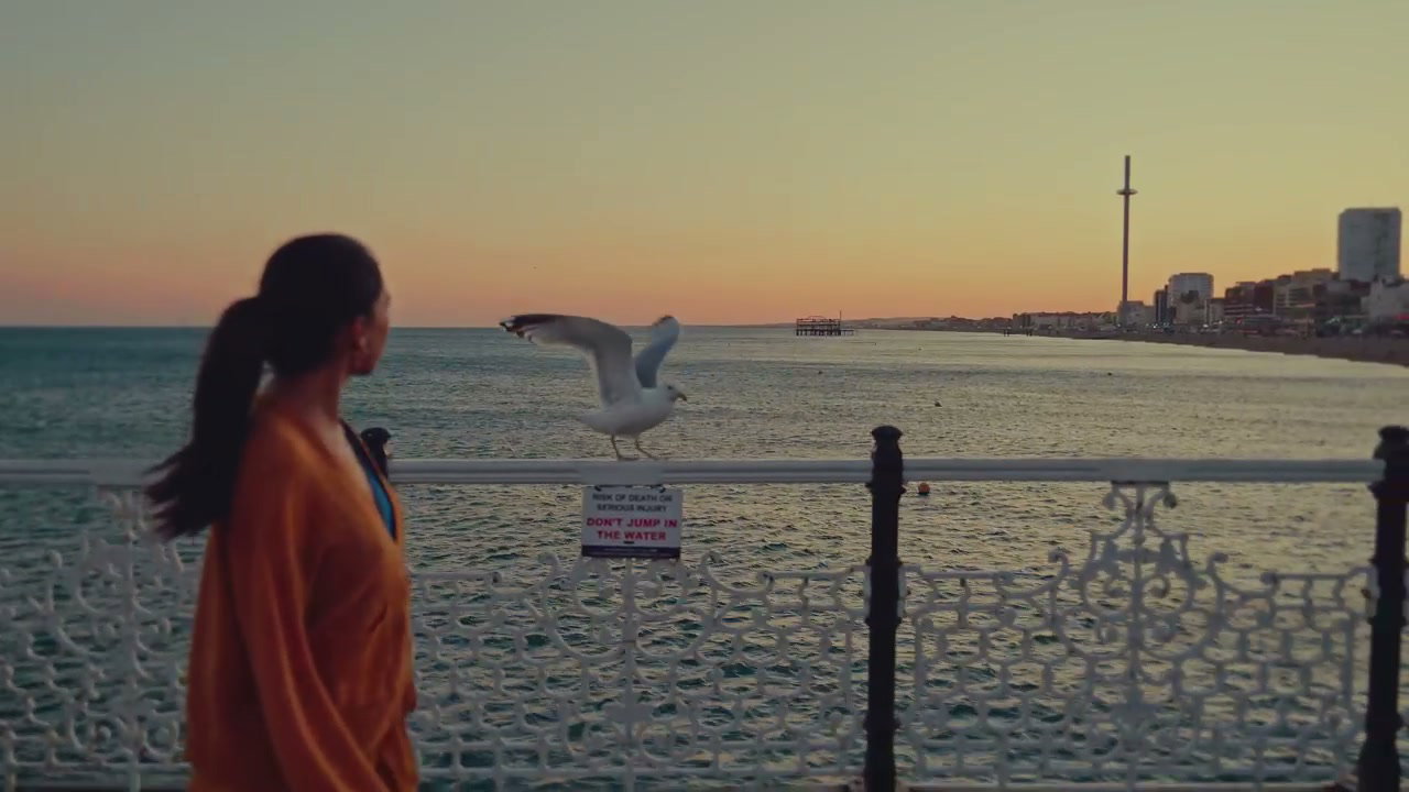 Woman Walking on Brighton Pier at Sunset
