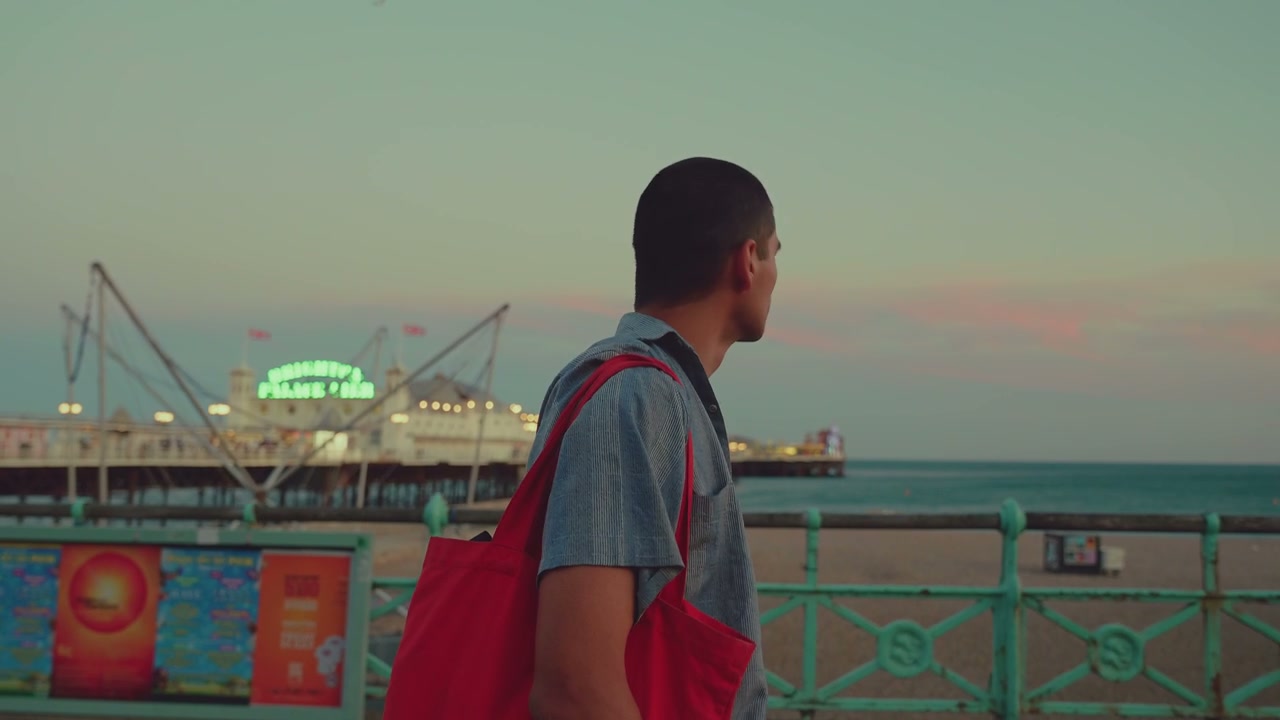 Person Walking on Brighton Promenade at Dusk