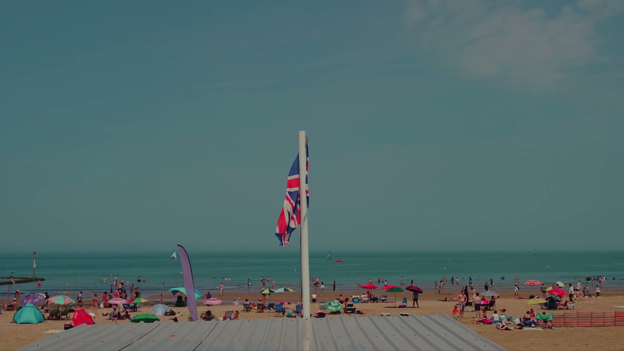 Union Jack Flag Waving on Crowded Margate Beach