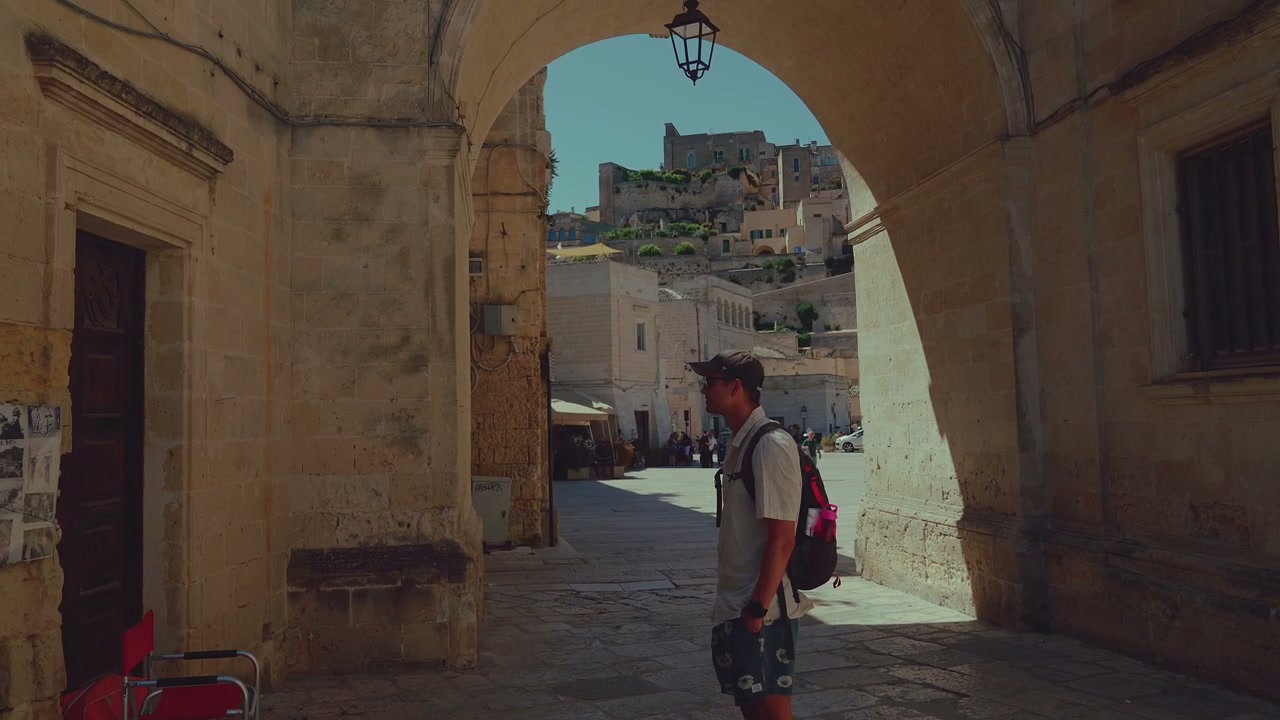 Man Stands Under Archway in Matera
