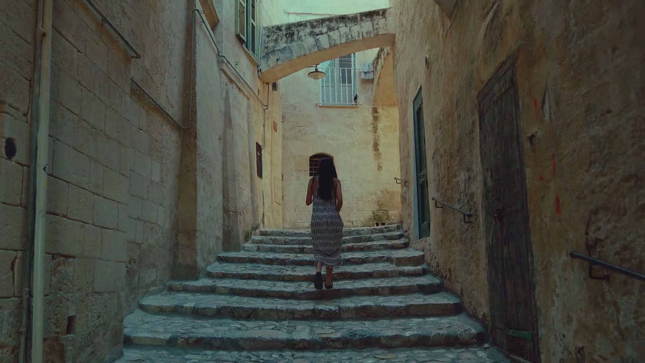 Woman Walking Up Stone Stairs in Matera