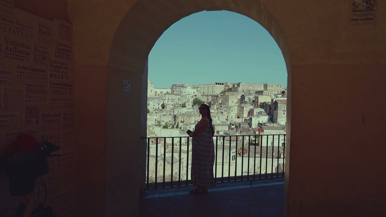 Woman Overlooking Matera Cityscape