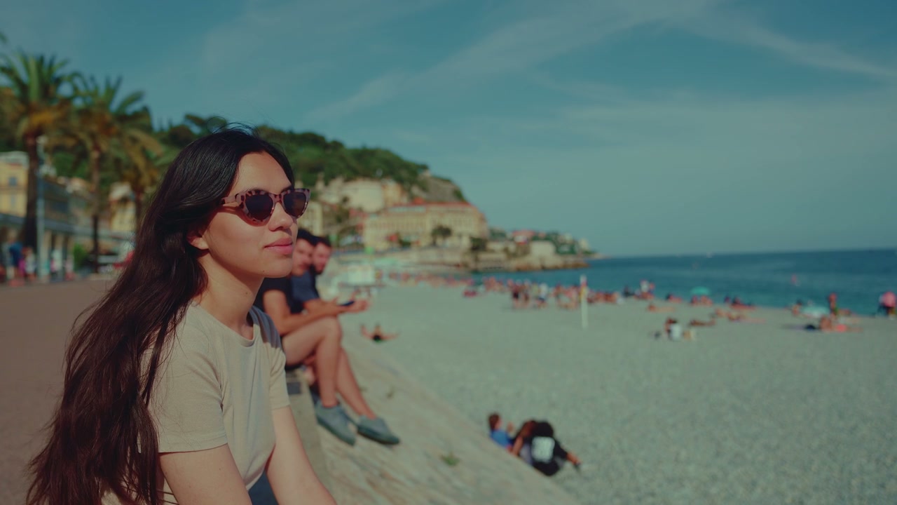 Young Woman Sitting on Beach Wall in Nice