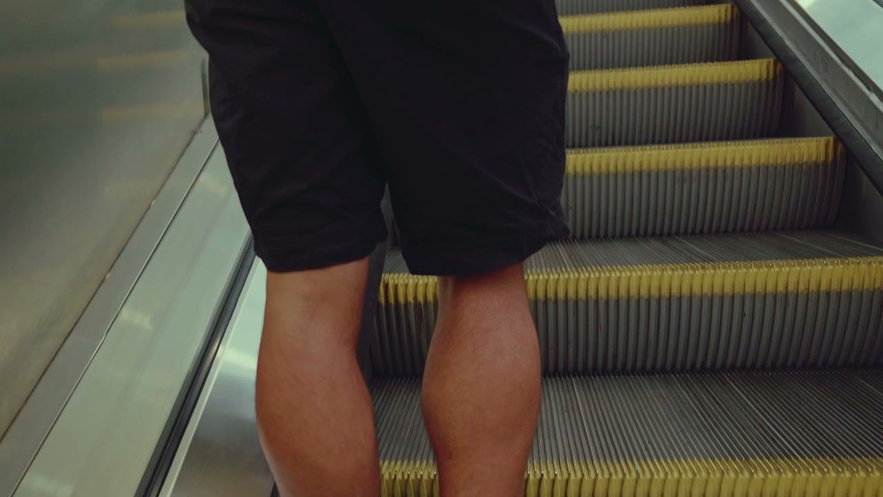 Person Riding Up Escalator