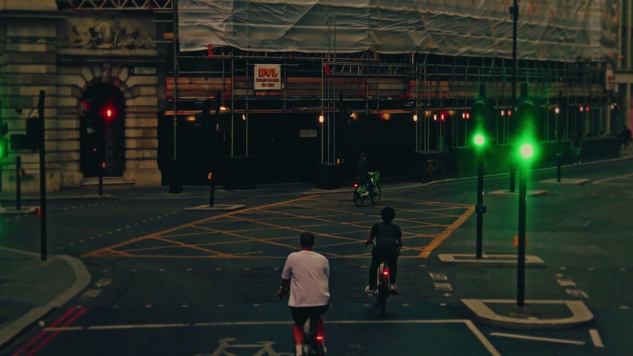 Cyclists Riding Through London City Intersection