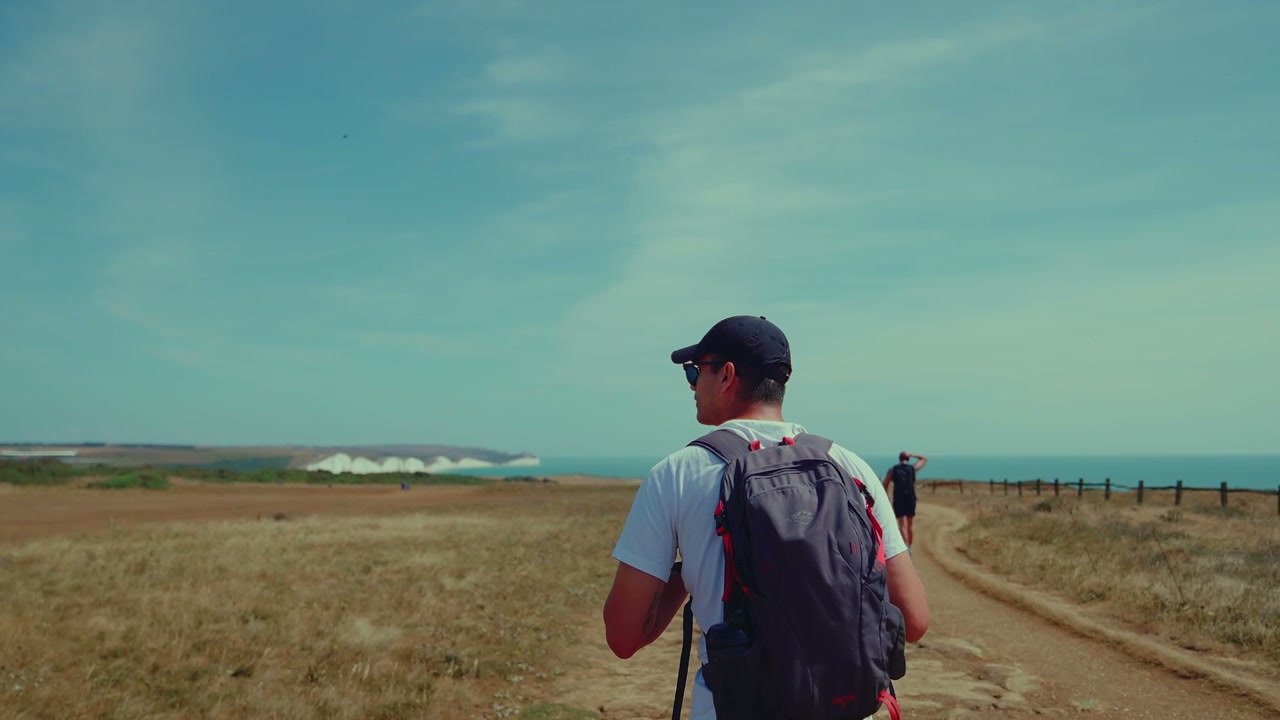 Man Hiking Coastal Path Near Seven Sisters Cliffs