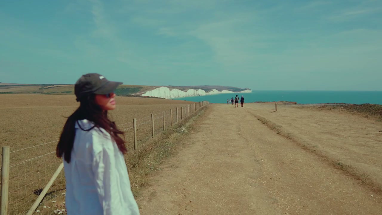 Woman Walks Along Coastal Path at Seven Sisters
