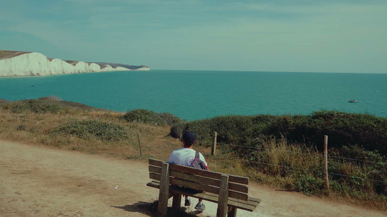 Man Sitting on Bench at Seven Sisters Cliffs