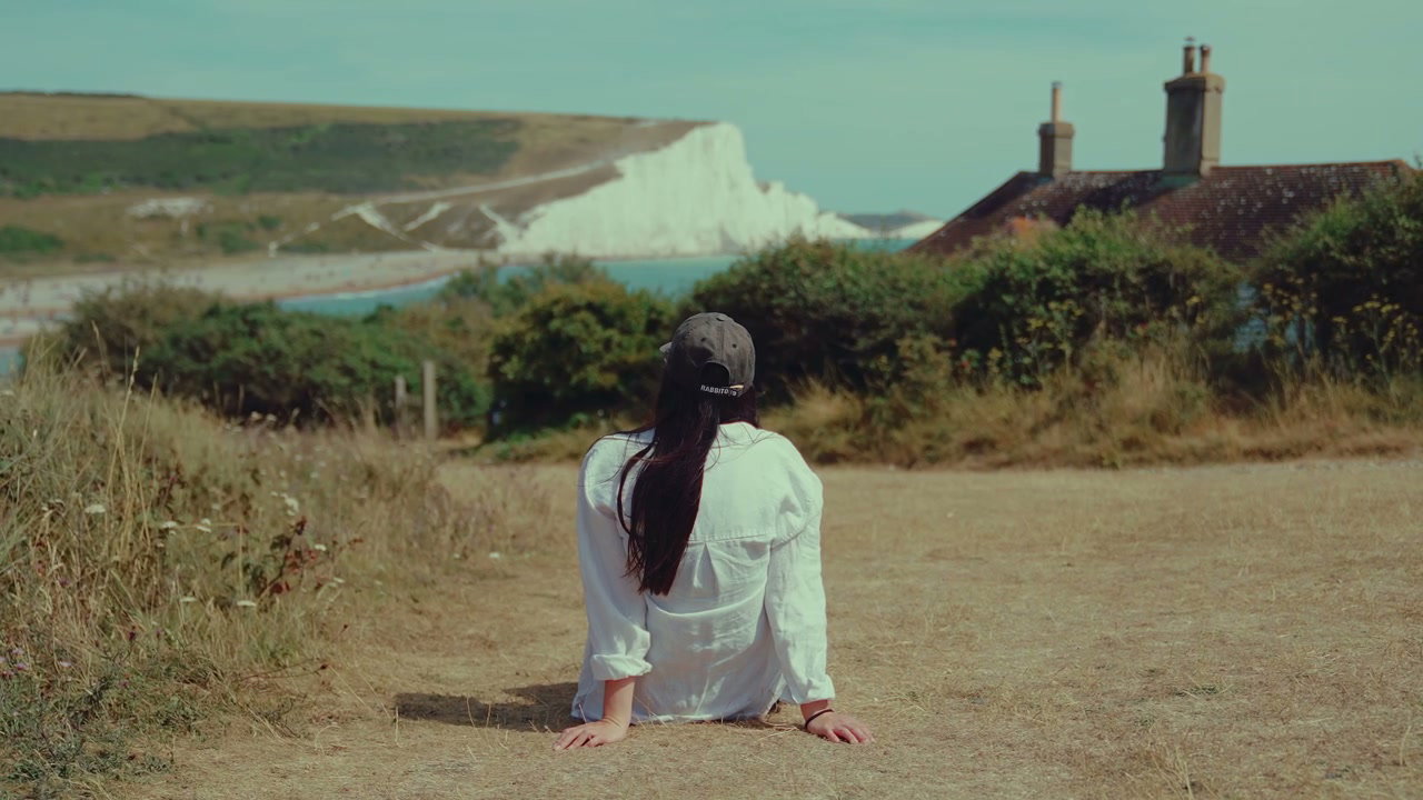 Woman Sitting on Cliffside Overlooking Seven Sisters