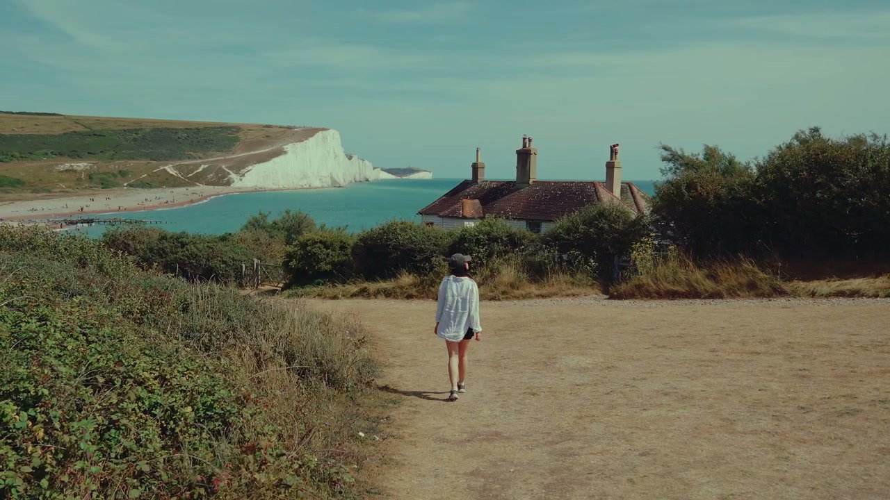 Person Walking on Path at Seven Sisters Cliffs