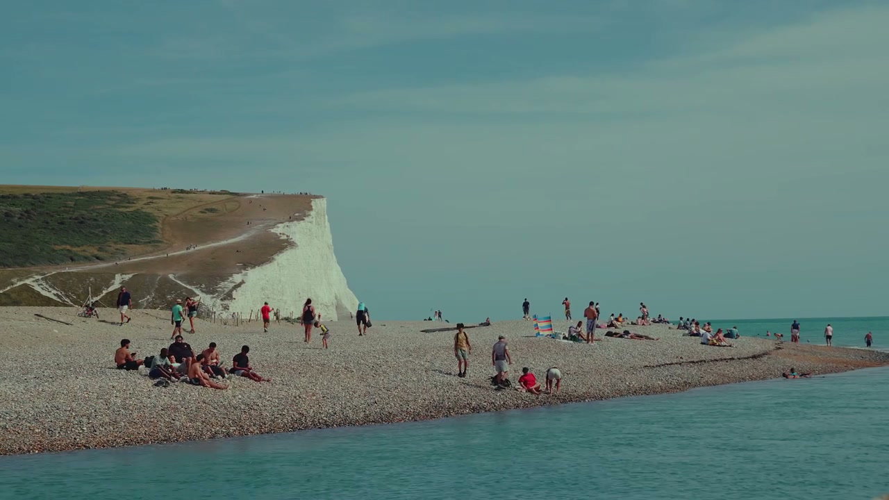 People Relaxing on Shingle Beach at Seven Sisters