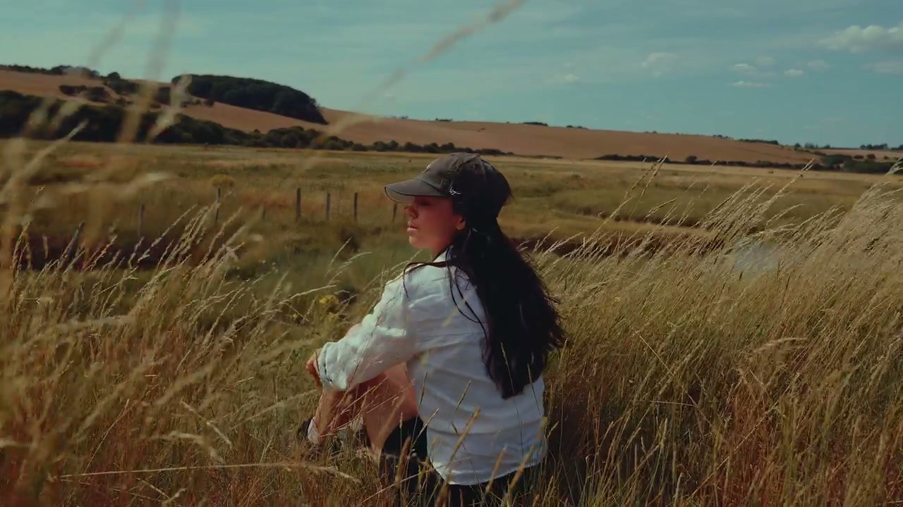 Woman Sits in Tall Grass, Seven Sisters