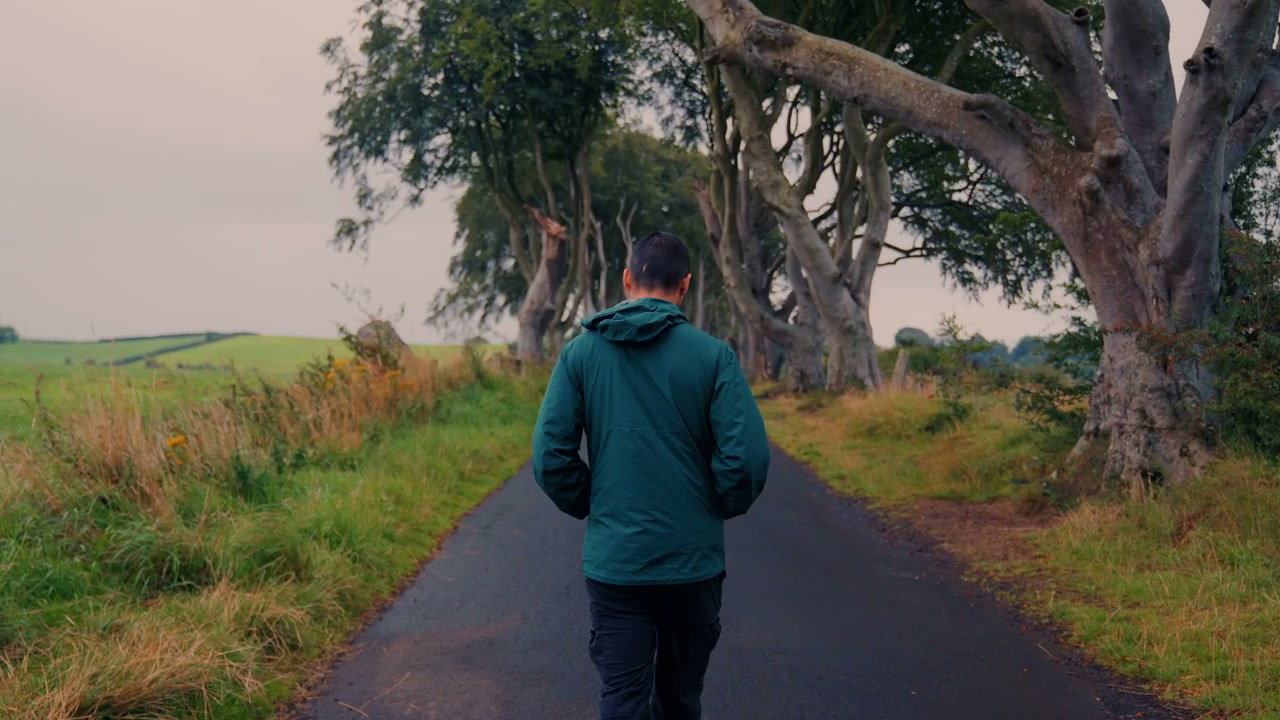 Man Walking Through Dark Hedges Avenue