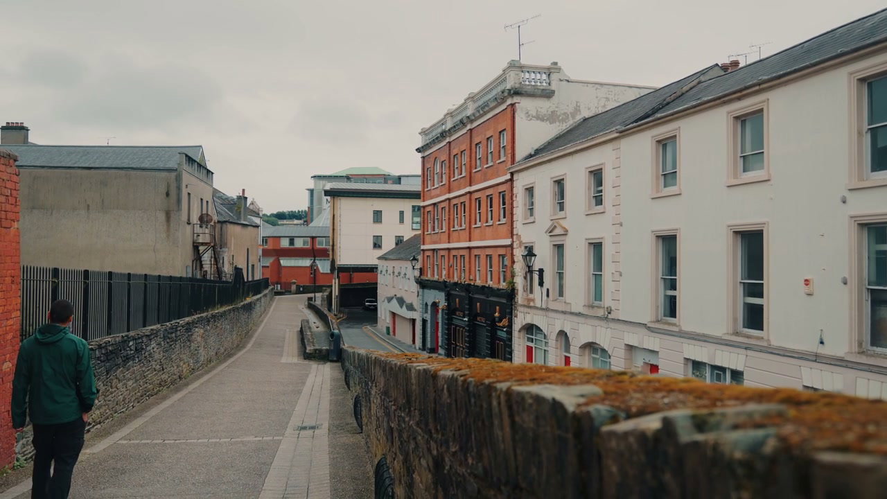 Man Walks Along Historic Street in Derry