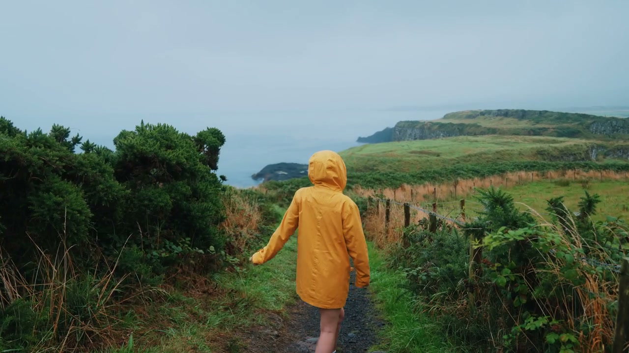 Woman in Yellow Raincoat at Giants Causeway