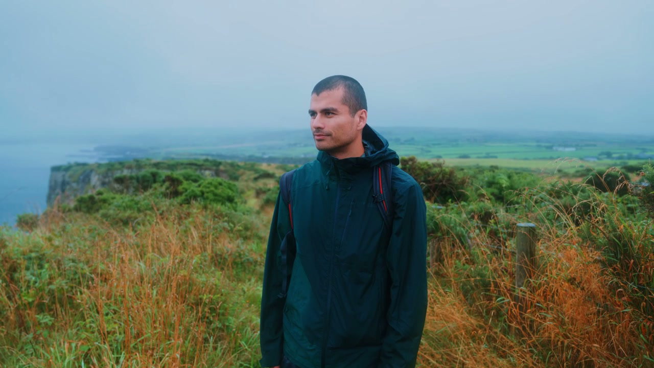 Man Standing on Cliff Edge at Giants Causeway