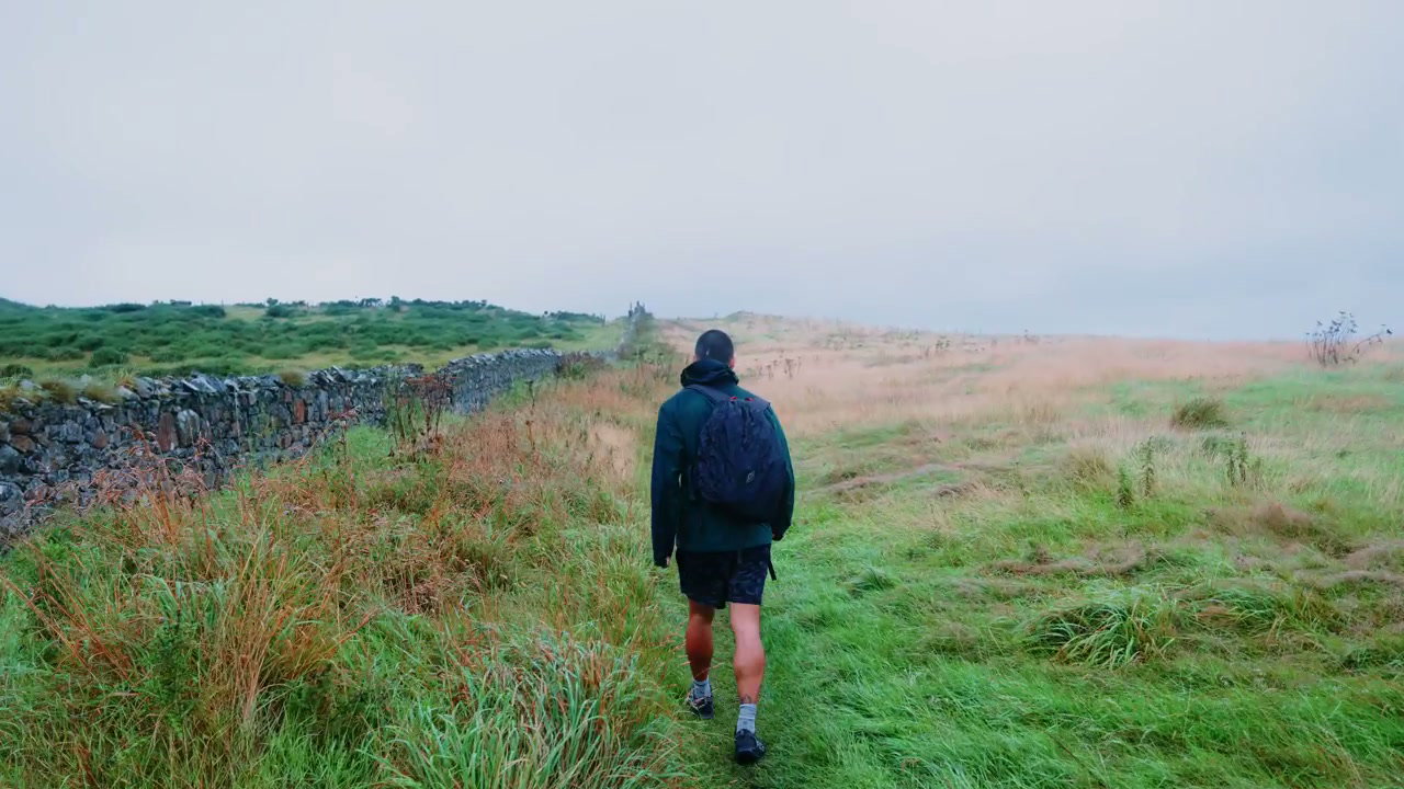 Person Hiking on a Grassy Coastal Path