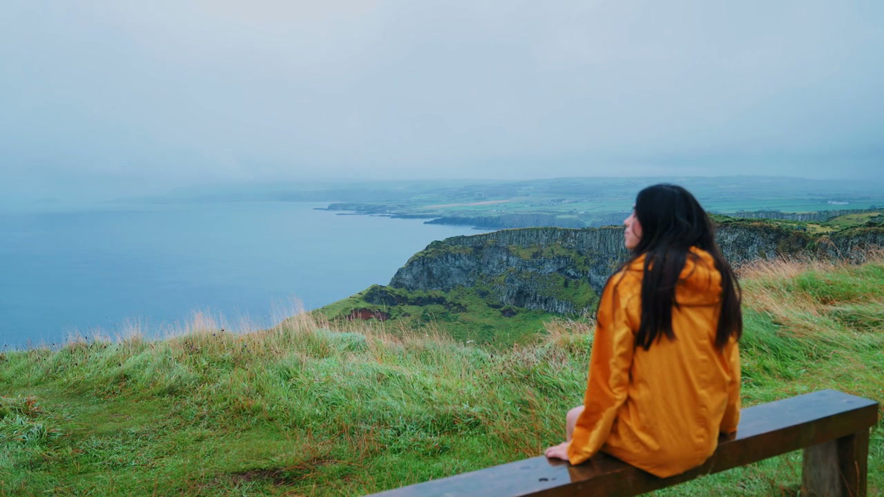 Woman Looking at Giant's Causeway Cliffs