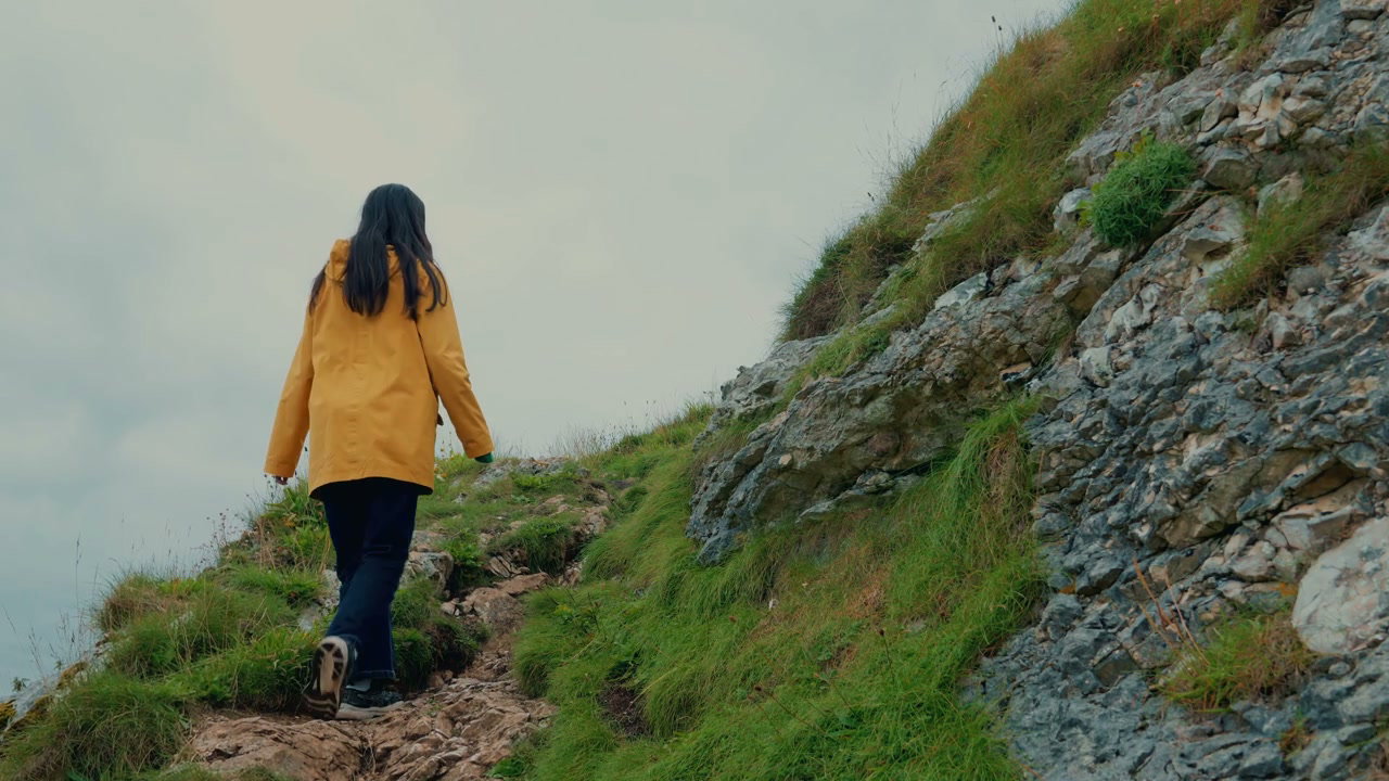 Person Hiking Rocky Slope Near Kinbane Castle