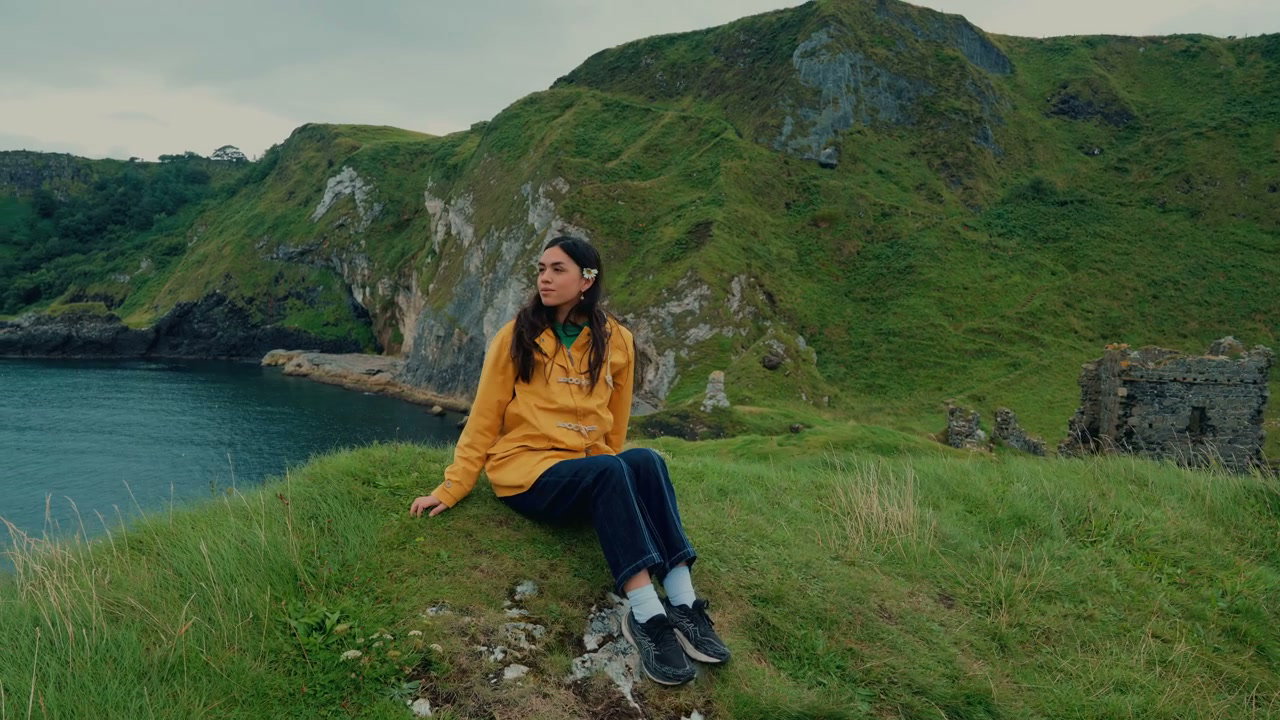 Young Woman Sits on Cliff Edge at Kinbane Castle