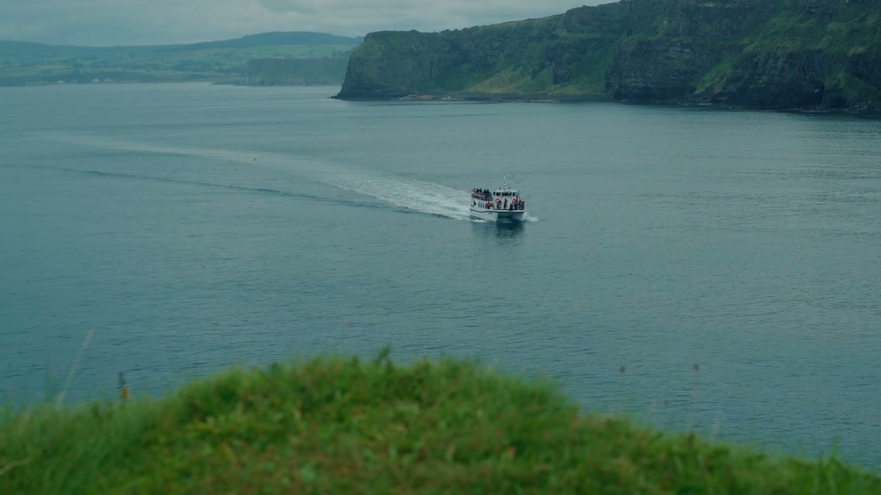 Tour Boat Sailing Past Coastal Cliffs