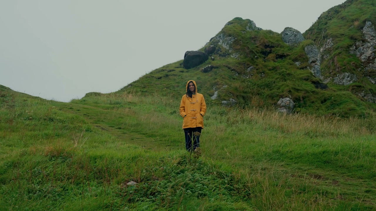 Person in Yellow Raincoat on Grassy Hill, Kinbane Castle