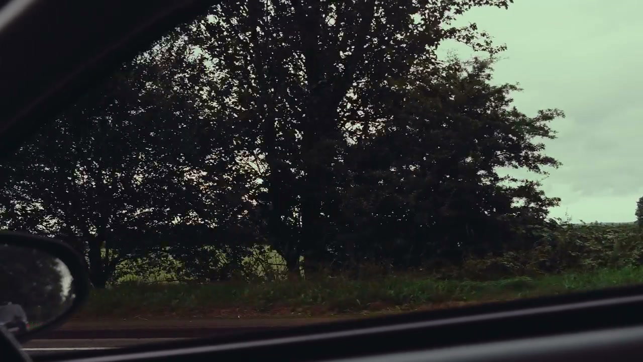Driving Past Countryside Fields with Wind Turbine