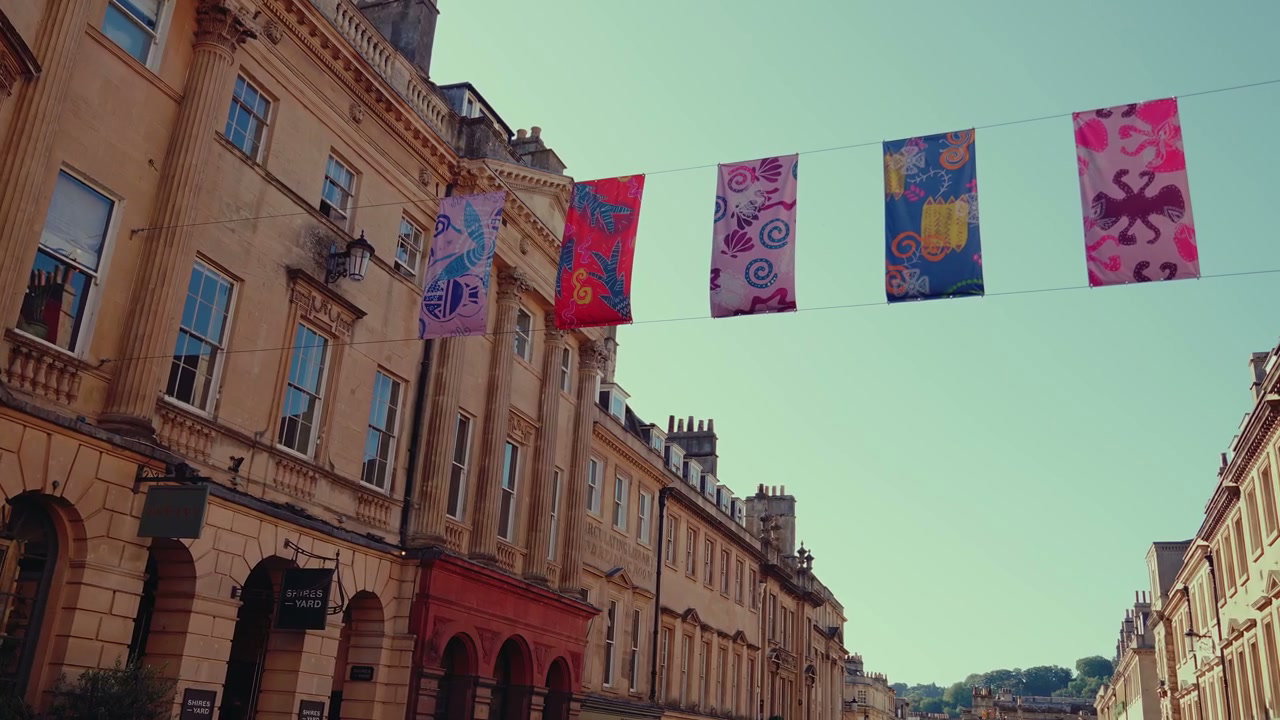 Colorful Flags Over Historic Buildings in Bath, England