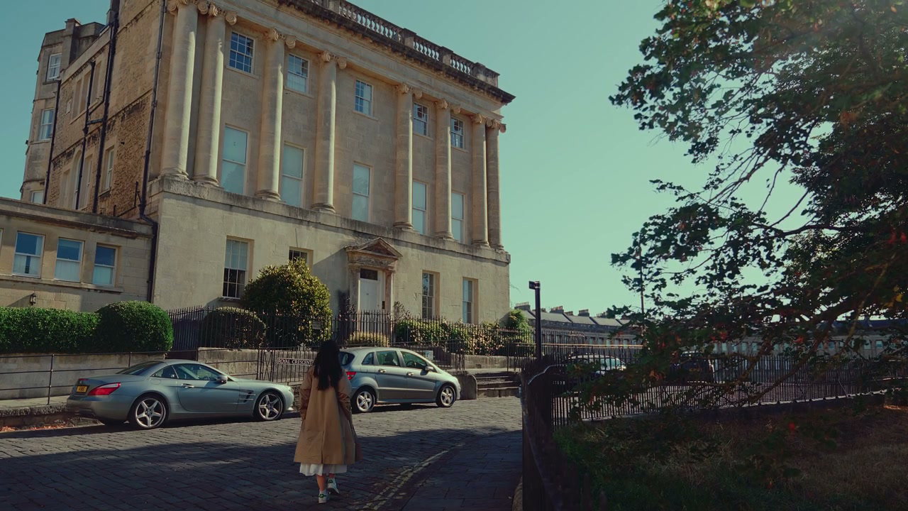 Woman Walking Down Street Past Georgian Building