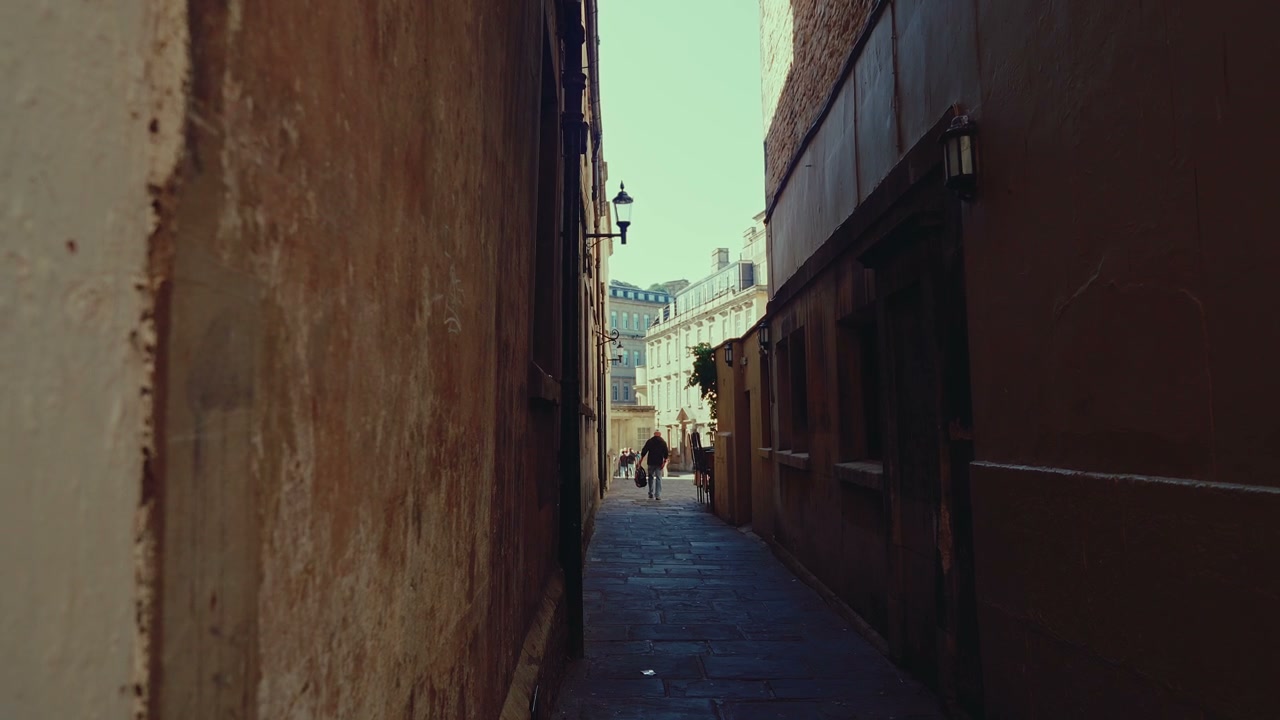 Person Walking Down Narrow Historic Alleyway