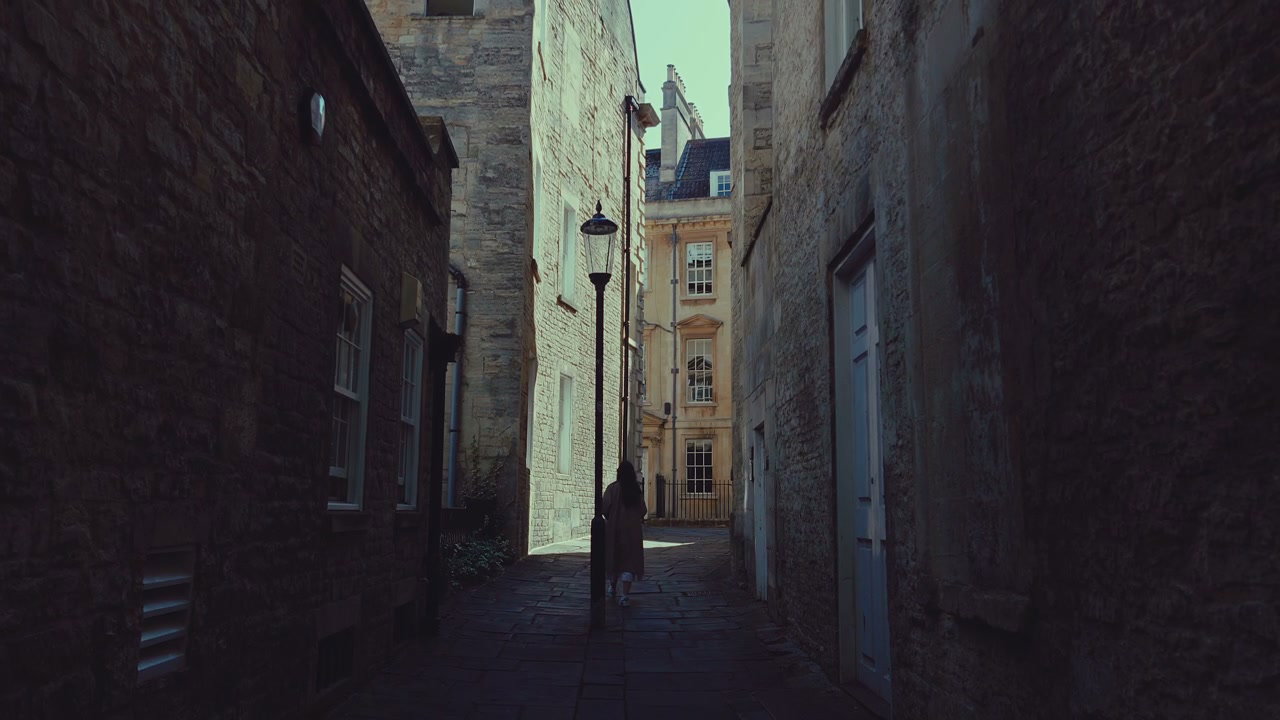 Woman Walking Through Historic Alley in Bath